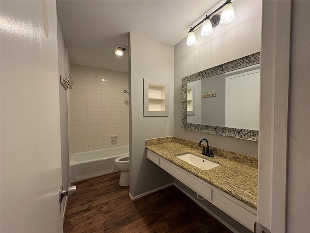 full bathroom with baseboards, shower / washtub combination, toilet, wood finished floors, and vanity