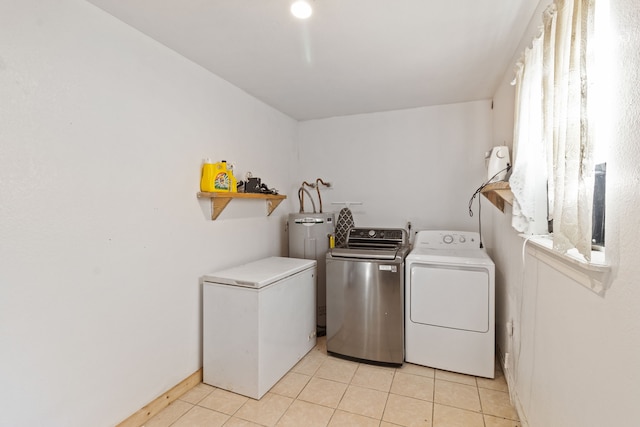 laundry room featuring washing machine and dryer, plenty of natural light, and light tile patterned floors