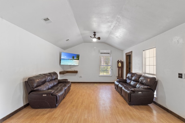 living room featuring light hardwood / wood-style floors, an AC wall unit, ceiling fan, and lofted ceiling