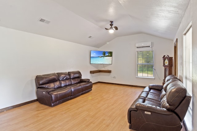 living room with hardwood / wood-style flooring, an AC wall unit, and lofted ceiling