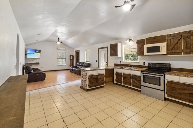 kitchen featuring kitchen peninsula, vaulted ceiling, ceiling fan, light tile patterned floors, and stainless steel electric range oven