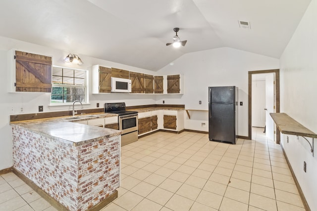 kitchen with lofted ceiling, black refrigerator, sink, stainless steel electric range oven, and light tile patterned floors