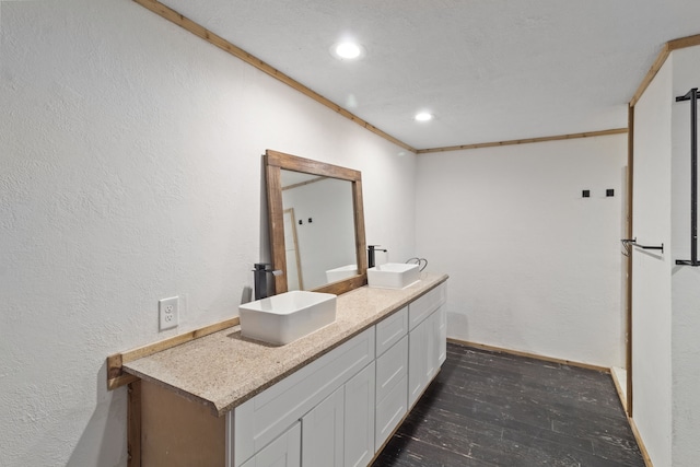 bathroom featuring hardwood / wood-style floors, vanity, and ornamental molding