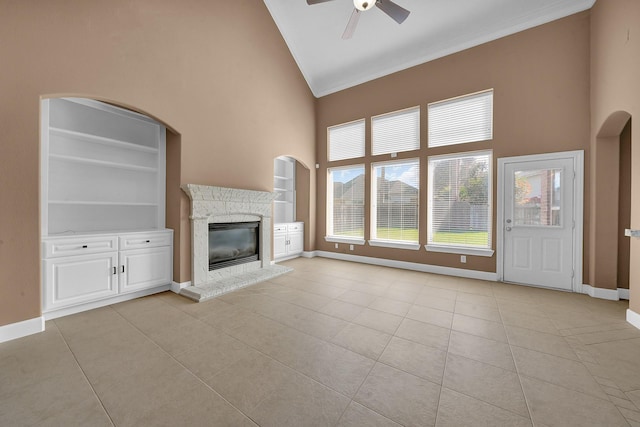 unfurnished living room with high vaulted ceiling, ceiling fan, built in features, and light tile patterned floors