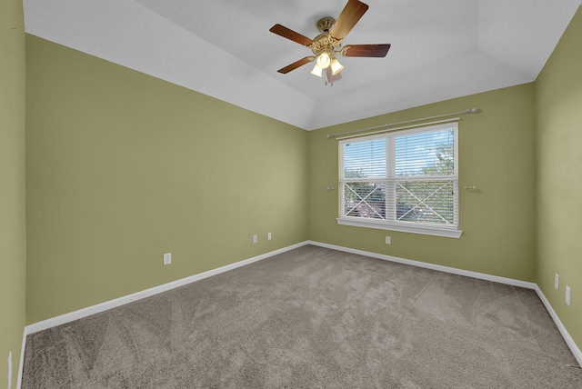 carpeted spare room with ceiling fan and a tray ceiling