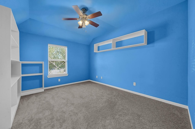 empty room featuring carpet floors, vaulted ceiling, and ceiling fan