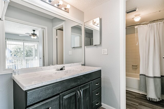 bathroom featuring shower / bath combination with curtain, vanity, a textured ceiling, ceiling fan, and wood-type flooring