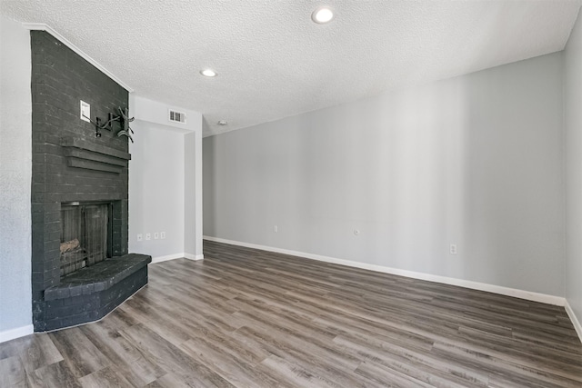 unfurnished living room featuring a fireplace, a textured ceiling, and hardwood / wood-style flooring