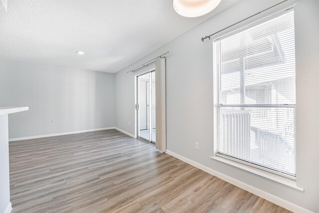 empty room featuring a textured ceiling and light hardwood / wood-style flooring