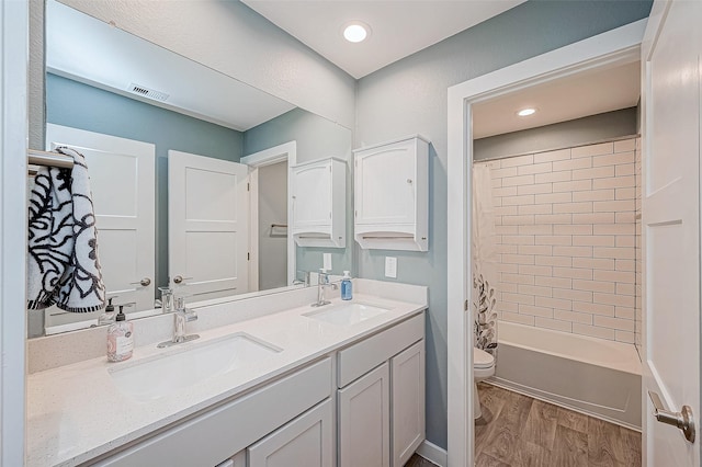 full bathroom with toilet, shower / bath combo, wood-type flooring, and vanity