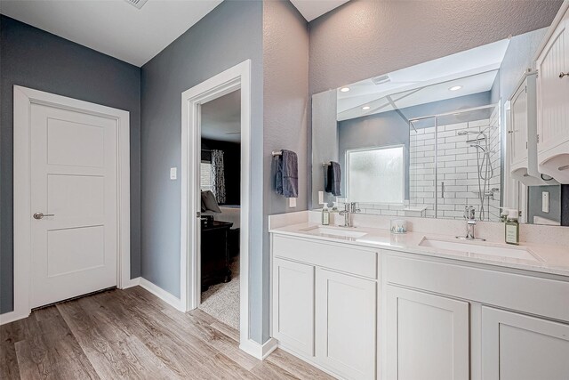 bathroom featuring an enclosed shower, vanity, and wood-type flooring