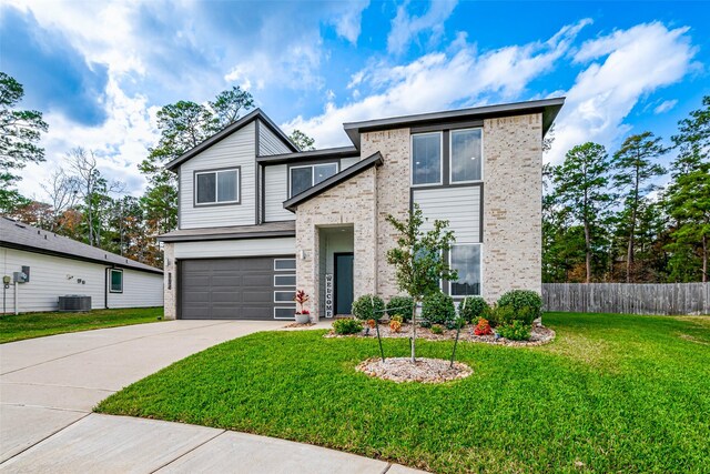 view of front of home featuring central AC unit, a front lawn, and a garage