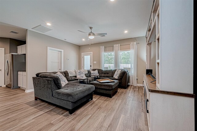 living room featuring ceiling fan and light hardwood / wood-style flooring