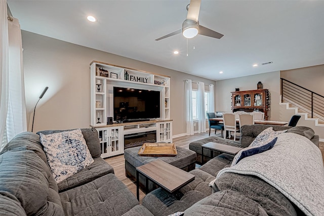 living room with ceiling fan and light hardwood / wood-style flooring