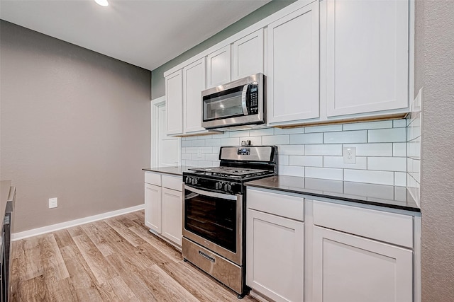 kitchen with white cabinets, stainless steel appliances, and decorative backsplash