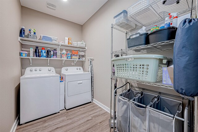 laundry room with light wood-type flooring and washing machine and clothes dryer