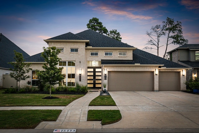 view of front of house featuring a garage and a lawn