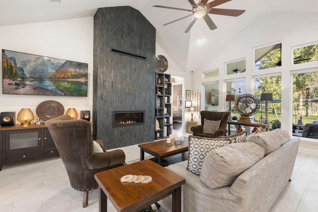 living room featuring a tiled fireplace, ceiling fan, and high vaulted ceiling