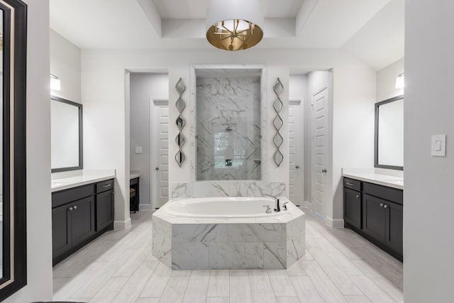 bathroom featuring vanity and tiled tub