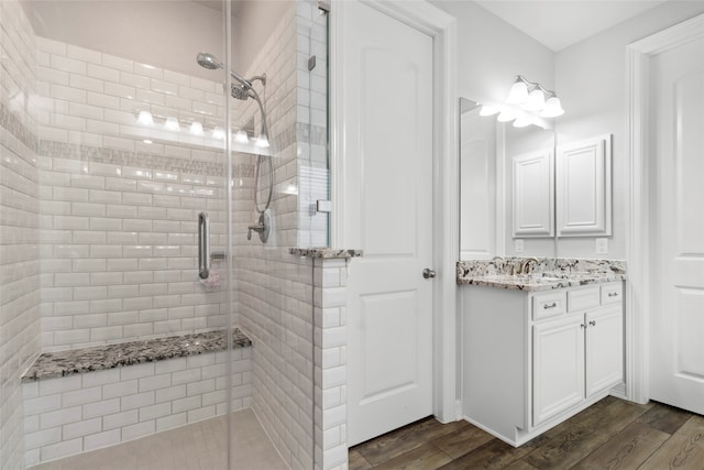 bathroom with a shower with door, hardwood / wood-style floors, and vanity