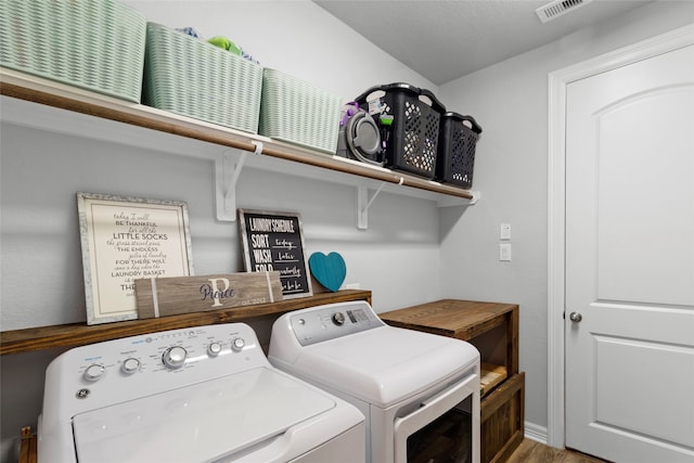 washroom featuring washing machine and dryer and hardwood / wood-style floors