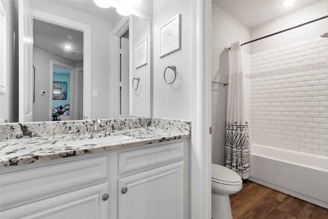 full bathroom featuring toilet, shower / bath combo with shower curtain, wood-type flooring, and vanity