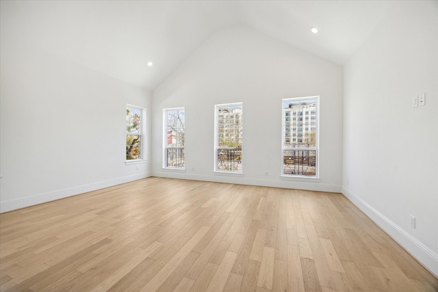 spare room with a high ceiling and light wood-type flooring