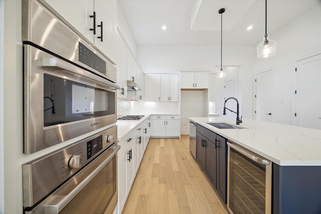 kitchen with white cabinets, sink, wine cooler, decorative light fixtures, and stainless steel appliances