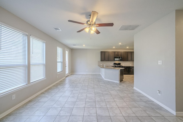 unfurnished living room featuring ceiling fan and light tile patterned flooring