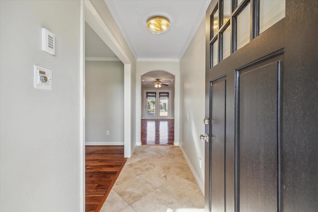 tiled entrance foyer with crown molding, french doors, and ceiling fan