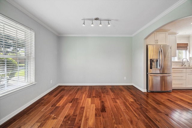 unfurnished dining area with crown molding, sink, and dark hardwood / wood-style floors