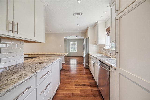 kitchen with white cabinets, plenty of natural light, sink, and stainless steel appliances