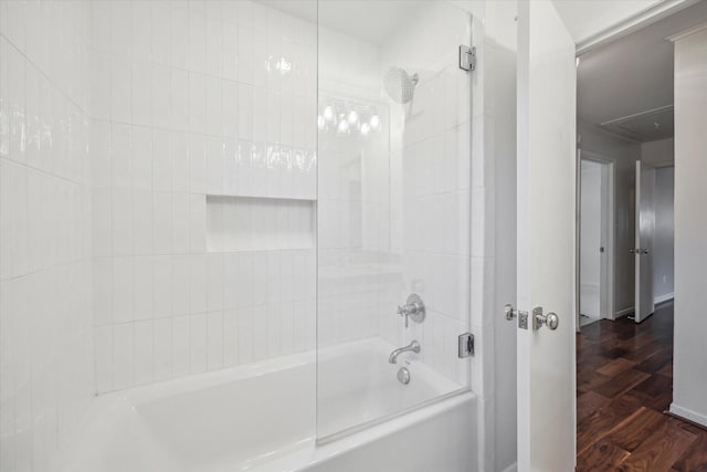 bathroom featuring hardwood / wood-style flooring and washtub / shower combination