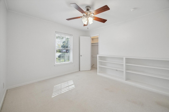 carpeted spare room with crown molding and ceiling fan