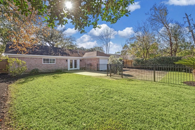 rear view of property with a yard, a patio, and french doors