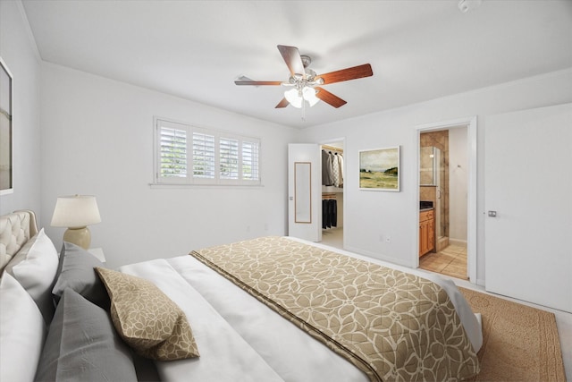 bedroom with ensuite bath, a walk in closet, a closet, and ceiling fan