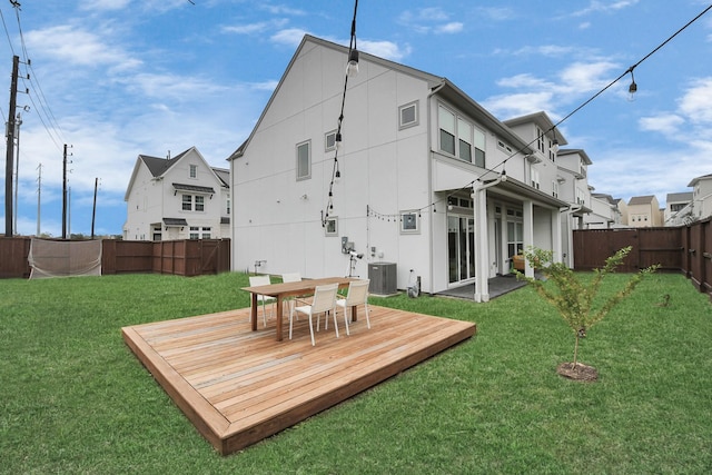 rear view of property with central AC unit, a yard, and a wooden deck