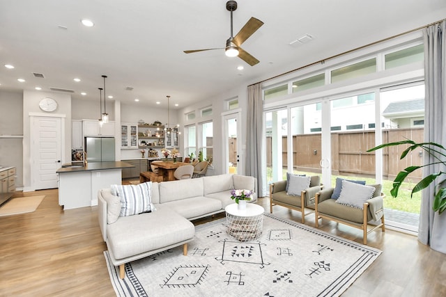 living room featuring light hardwood / wood-style flooring, ceiling fan, a healthy amount of sunlight, and sink