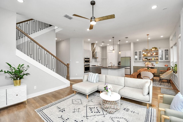 living room featuring wood-type flooring and ceiling fan