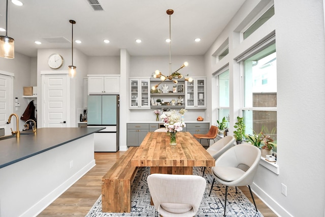 dining space featuring light wood-type flooring and an inviting chandelier