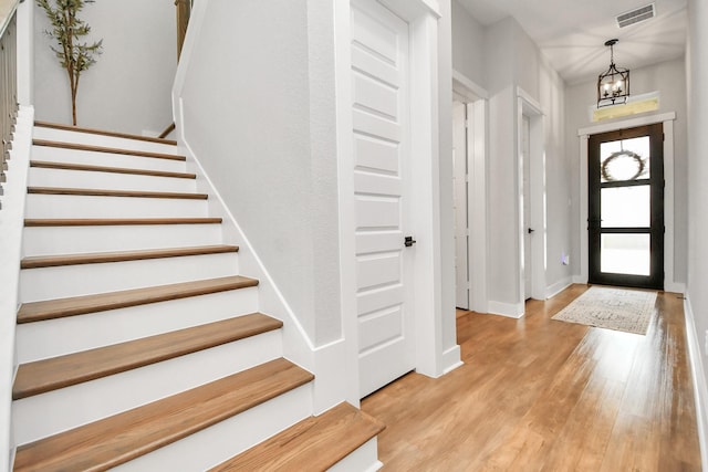 entryway featuring light hardwood / wood-style floors and an inviting chandelier