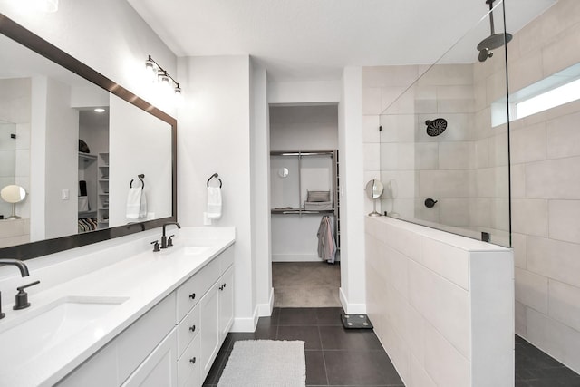 bathroom with a tile shower and vanity