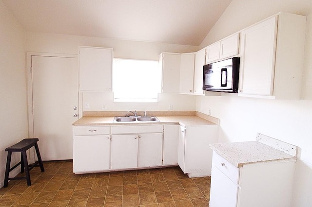 kitchen with sink, white cabinets, and vaulted ceiling