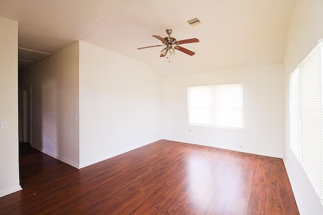 spare room featuring a healthy amount of sunlight, vaulted ceiling, ceiling fan, and dark wood-type flooring