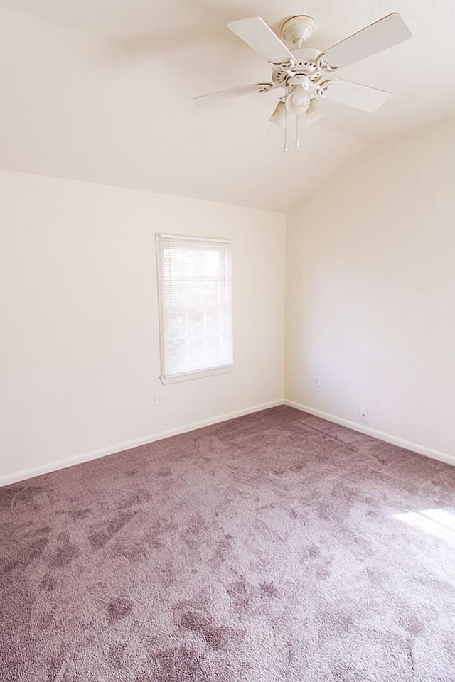 unfurnished room with ceiling fan, carpet floors, and vaulted ceiling