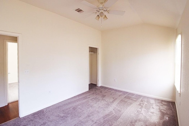 carpeted spare room with ceiling fan and vaulted ceiling