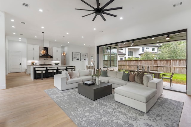 living room featuring ceiling fan and light hardwood / wood-style floors