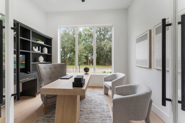 home office with light hardwood / wood-style flooring