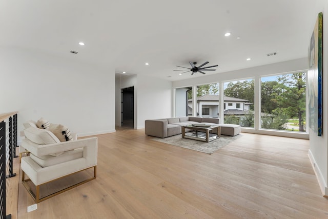 living room with ceiling fan and light hardwood / wood-style flooring