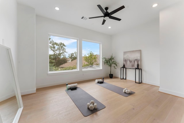 exercise room with light wood-type flooring and ceiling fan